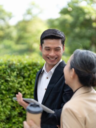 Portrait of young and senior business people working together with digital tablet outdoor