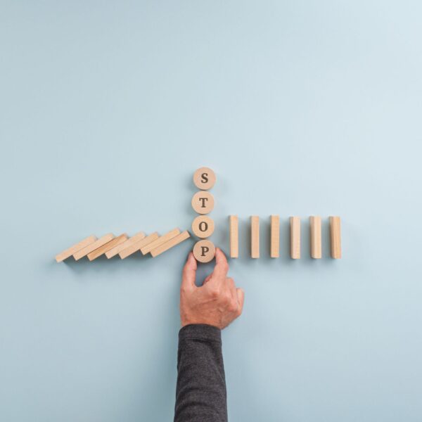 stop-sign-in-the-middle-of-collapsing-dominos-2026-03-19-01-56-30-utc