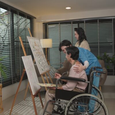 Group of Asian old women sit wheelchair in nursing home Concentrate happy draw, paint canva with nurse, mental health of elderly people, art therapy for seniors. retirement hobby